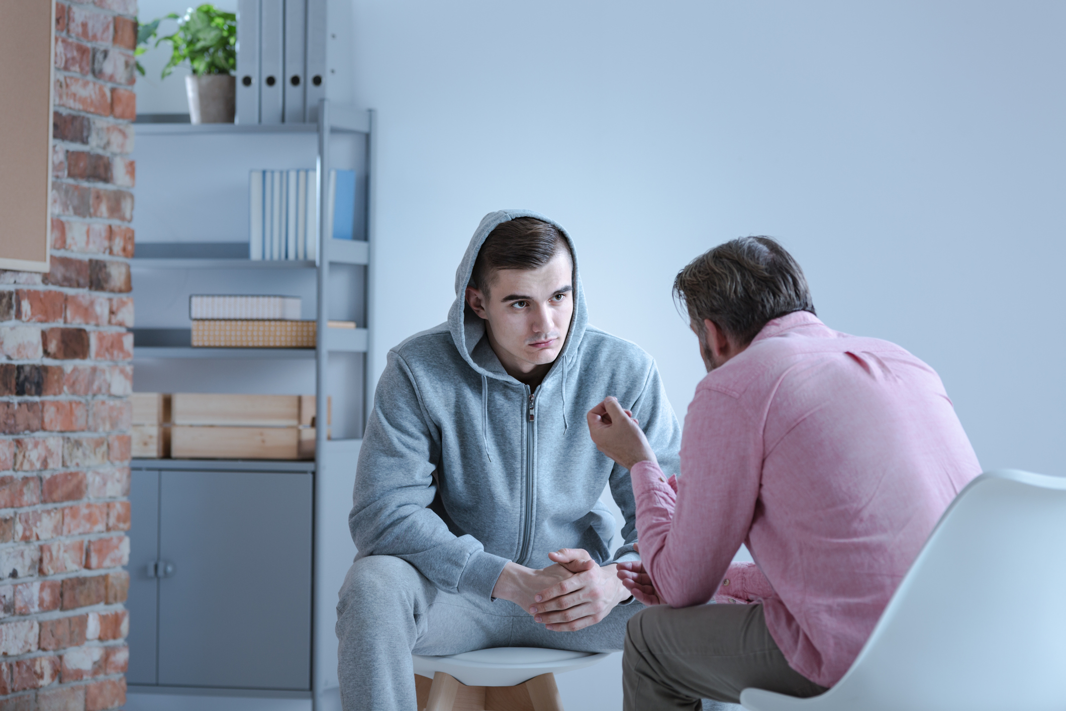 Young man undergoing outpatient rehab treatment with a therapist.